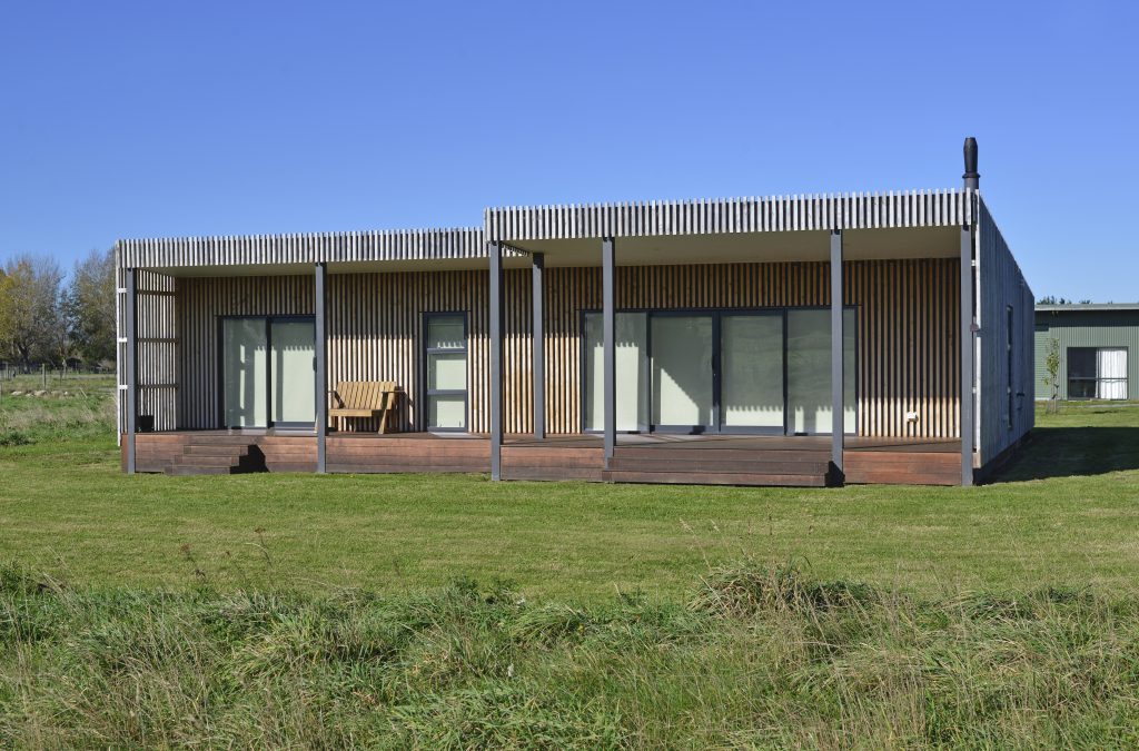 The outside of a newly built house with vertical slatted timber cladding