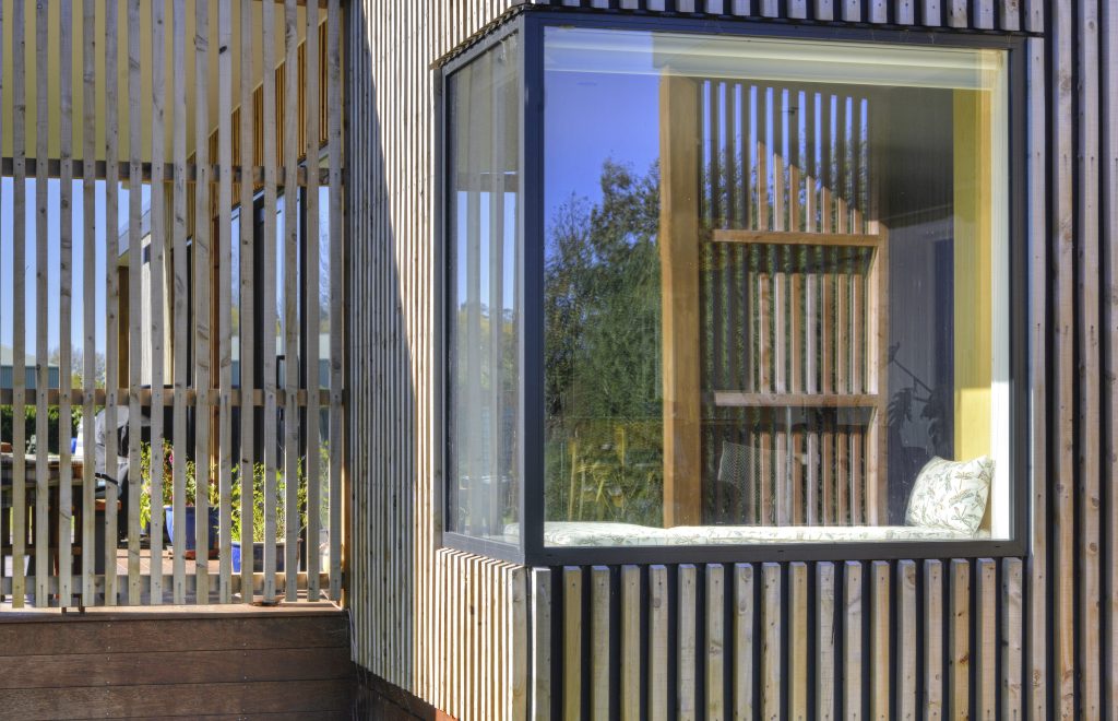 The outside of a newly built house with vertical slatted timber cladding
