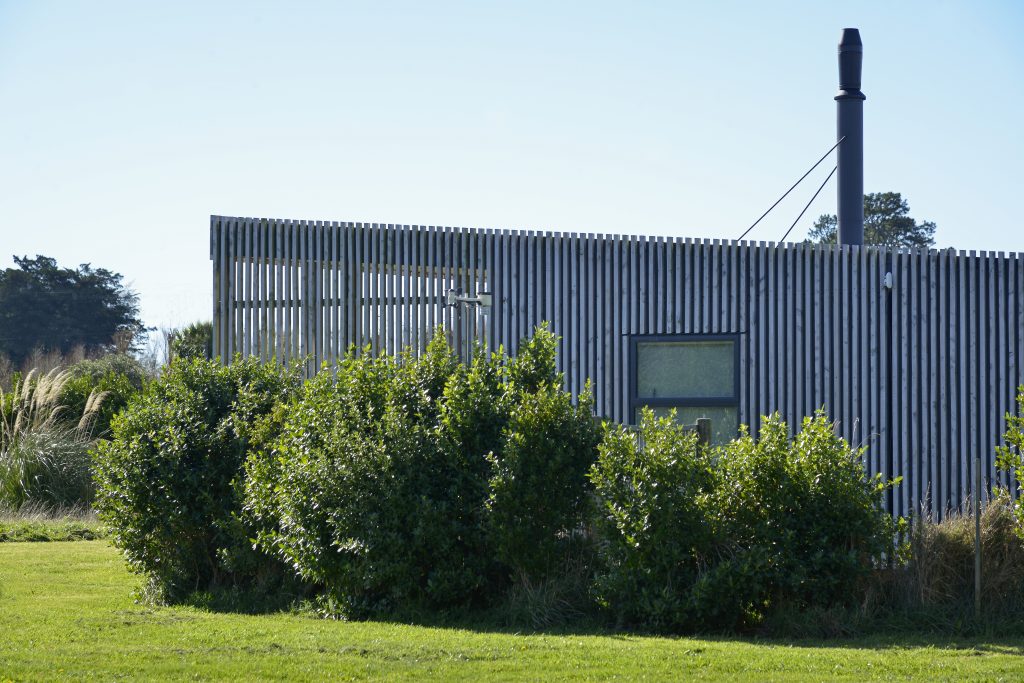 The outside of a newly built house with vertical slatted timber cladding