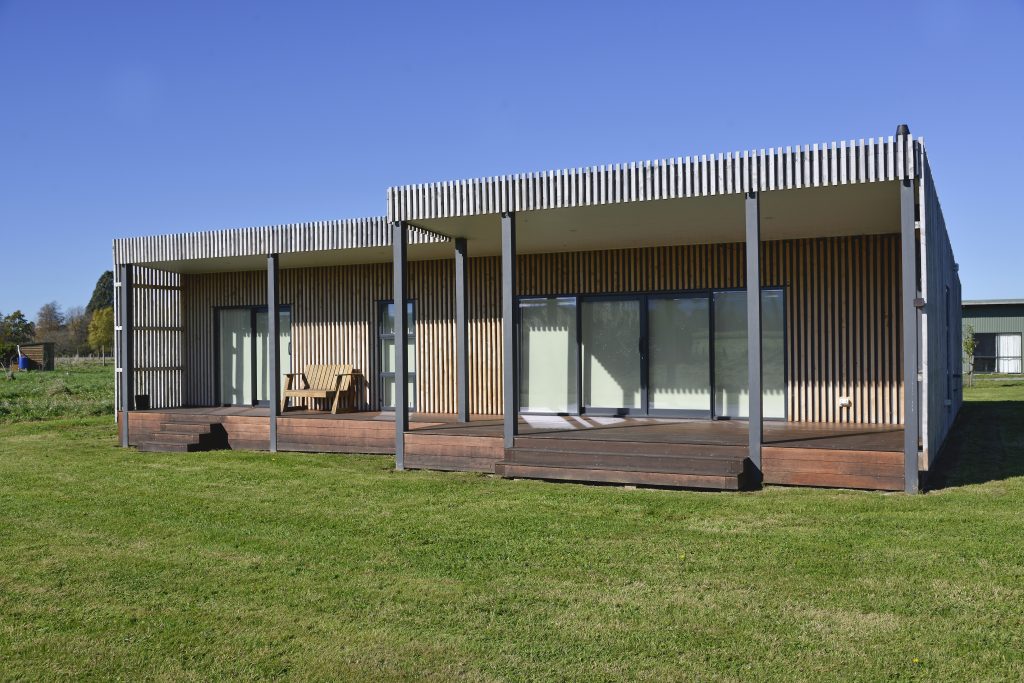 The outside of a newly built house with vertical slatted timber cladding