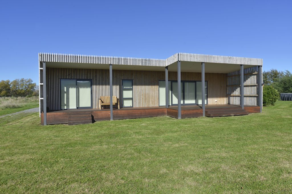 The outside of a newly built house with vertical slatted timber cladding