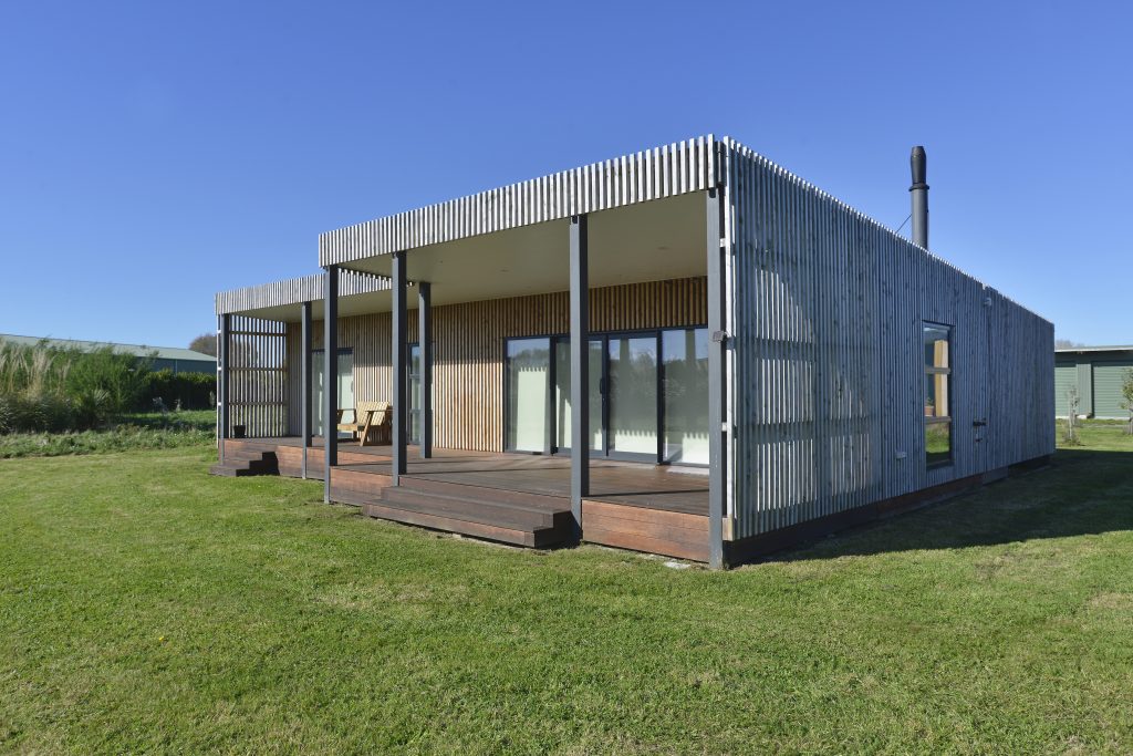 The outside of a newly built house with vertical slatted timber cladding