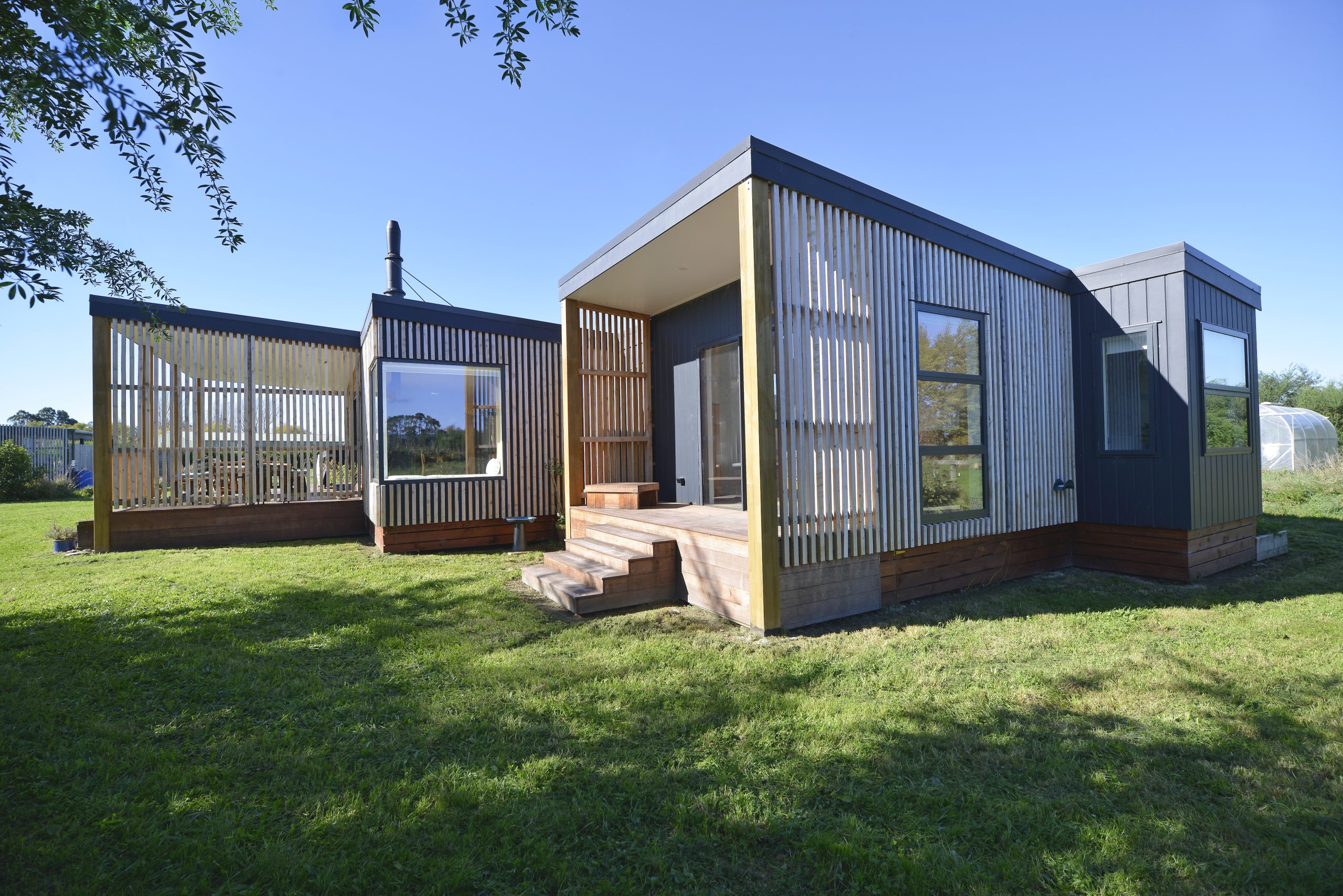 The outside of a newly built house with vertical slatted timber cladding