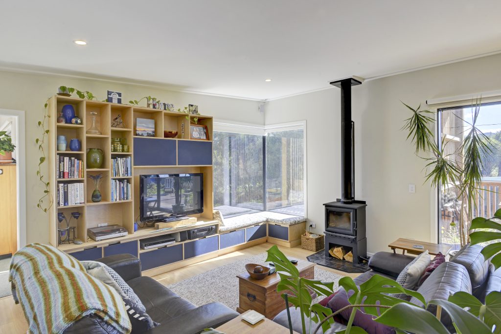 A newly built living space with free standing wood burner fireplace and modern wooden shelving