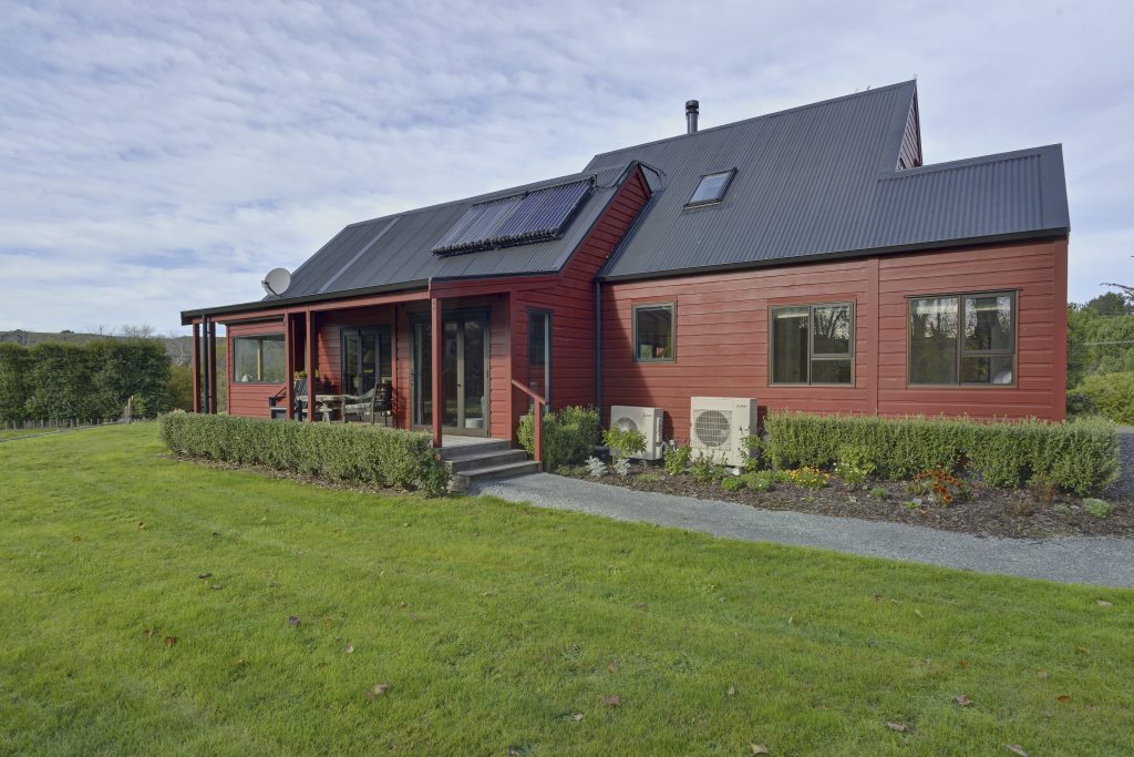 The exterior of a freshly renovated built red house