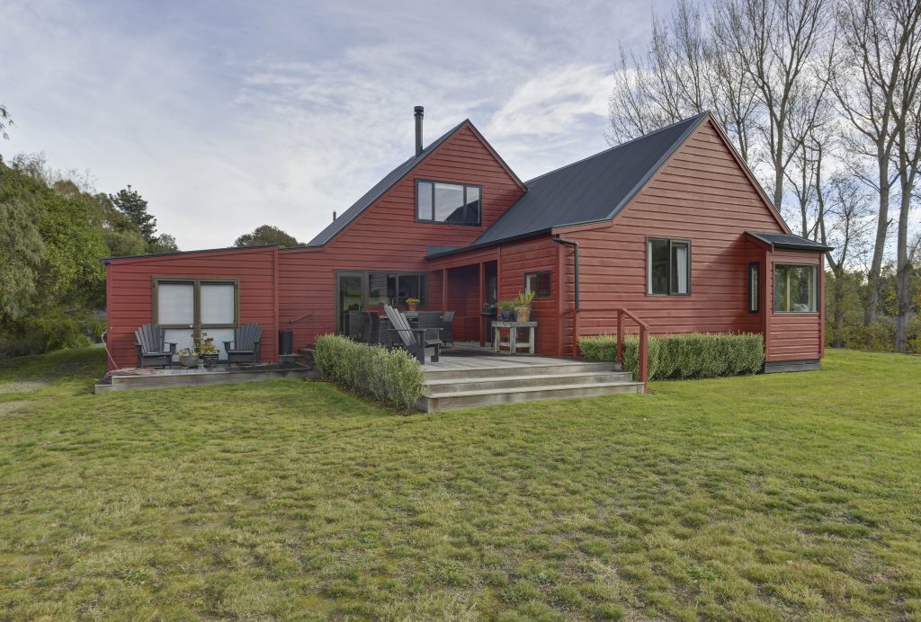 The exterior of a freshly renovated built red house