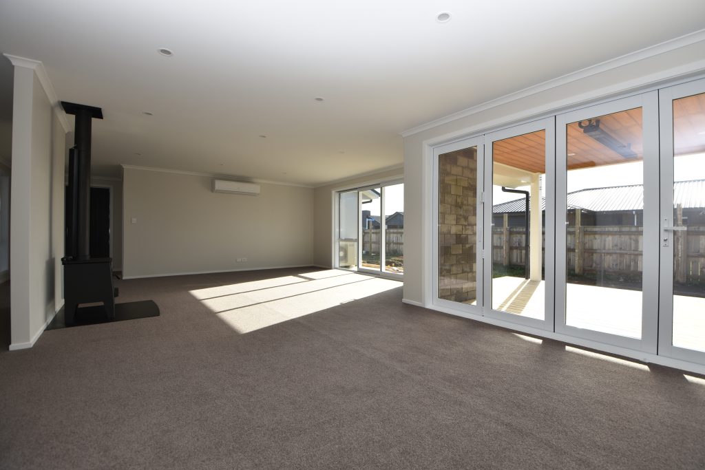 A freshly built and empty open-plan living space with free standing wood burner fireplace