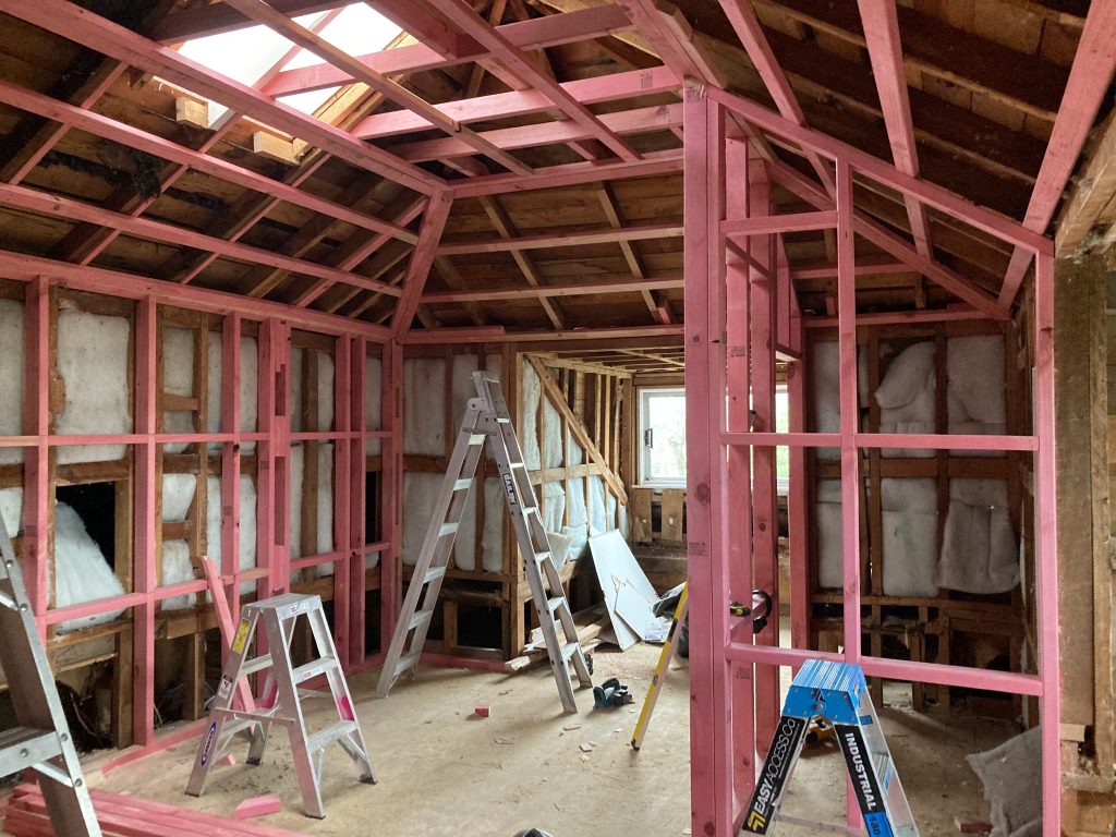 The inside of a house undergoing a renovation showing exposed framing and various builders tools