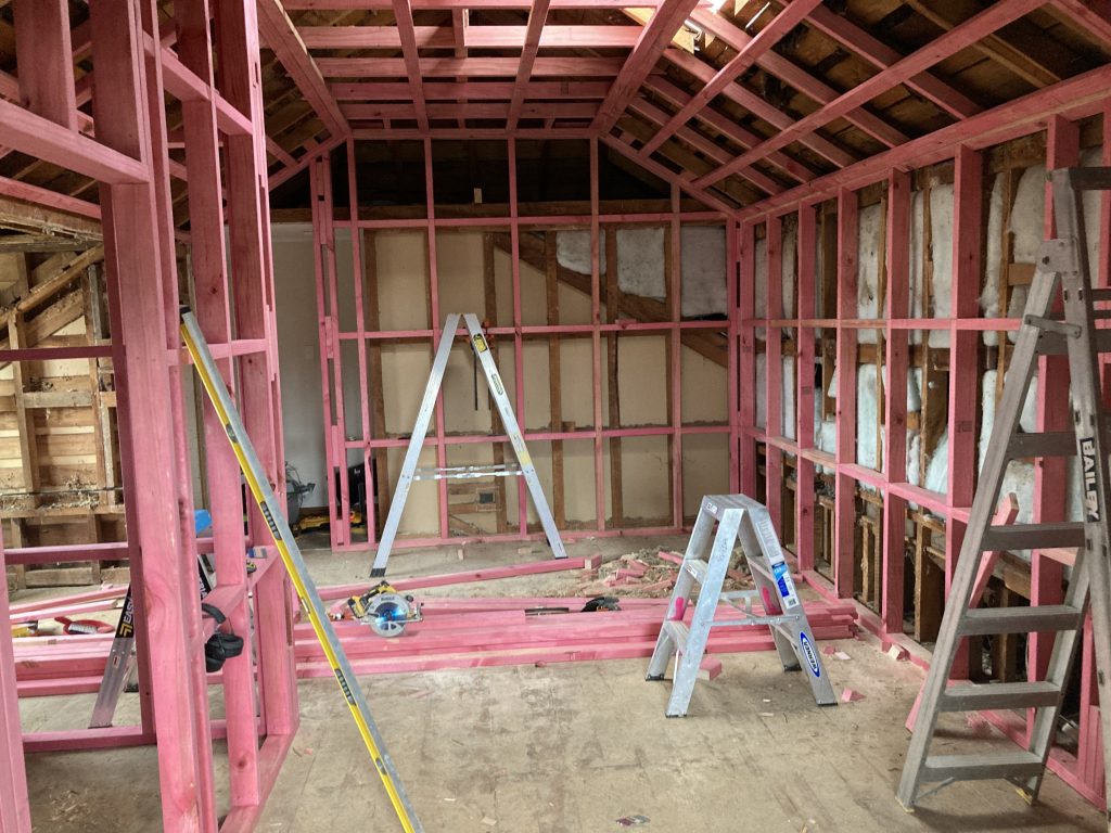 The inside of a house undergoing a renovation showing exposed framing and various builders tools